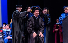 GSE faculty hooding a doctoral candidte at the 2023 commencement ceremony. 