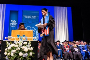 Zoom image: Michele Agosto accepting the Excellence in Community Outreach and Engagement Award at the 2023 commencement ceremony