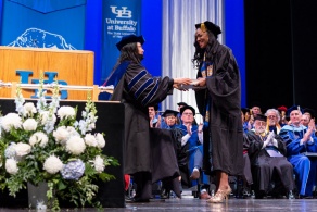 Zoom image: Melodie Baker accepting the Excellence in Research award at the 2023 commencement ceremony. 