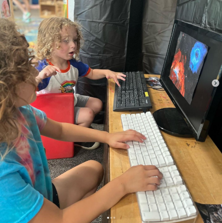A screenshot of an Instagram post, with young children typing at a computer. 