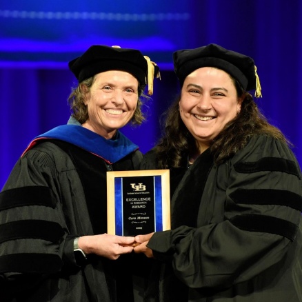 Zoom image: Cara Monaco receives Excellence in Research Award from Dean Suzanne Rosenblith.