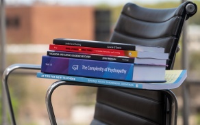 Stack of books published by GSE faculty. 
