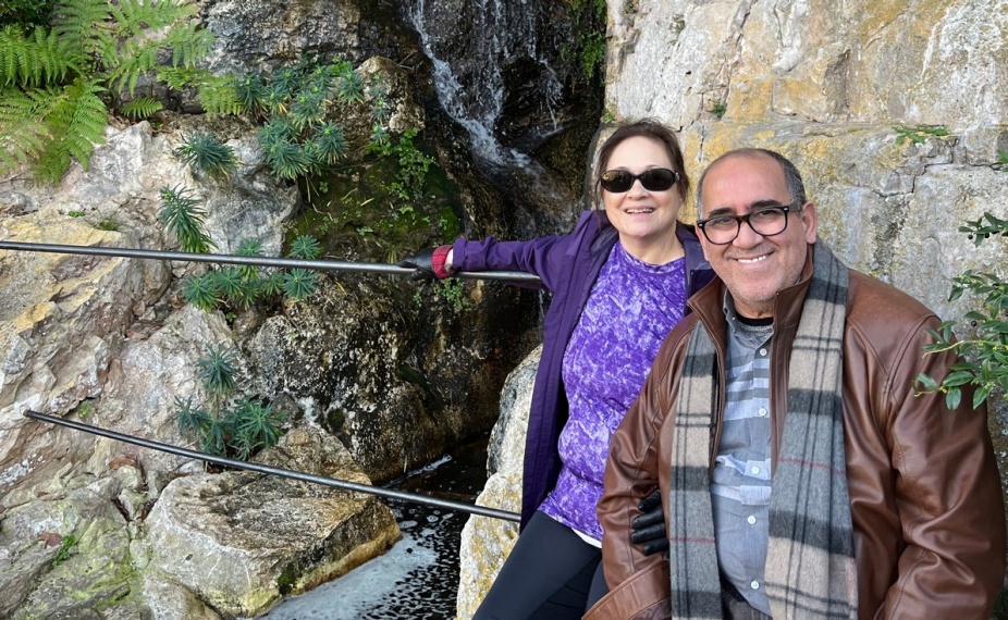 Cherif Sadki and his wife pose in front of waterfall and rocks. 