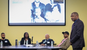 Dr. Howard Stevenson presenting with the panelists in the background. 