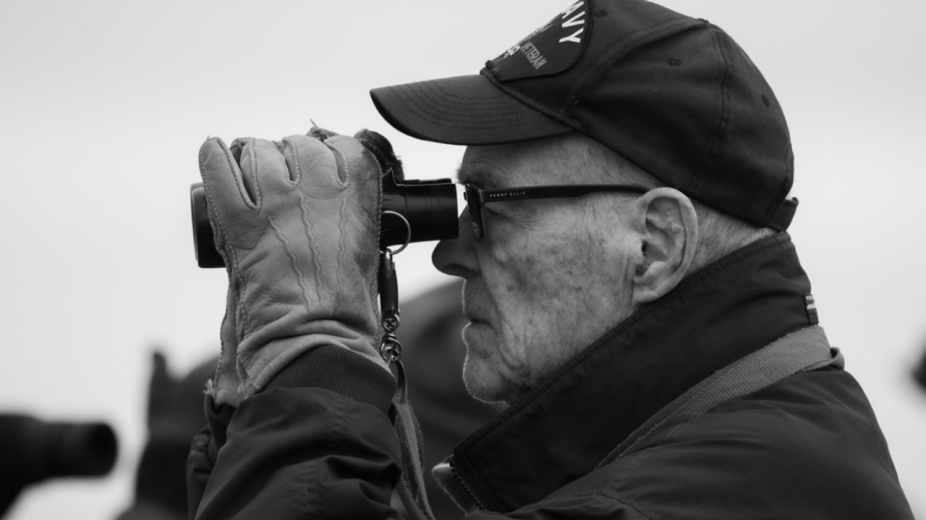 Image of Gerry Rising looking through binoculars. 