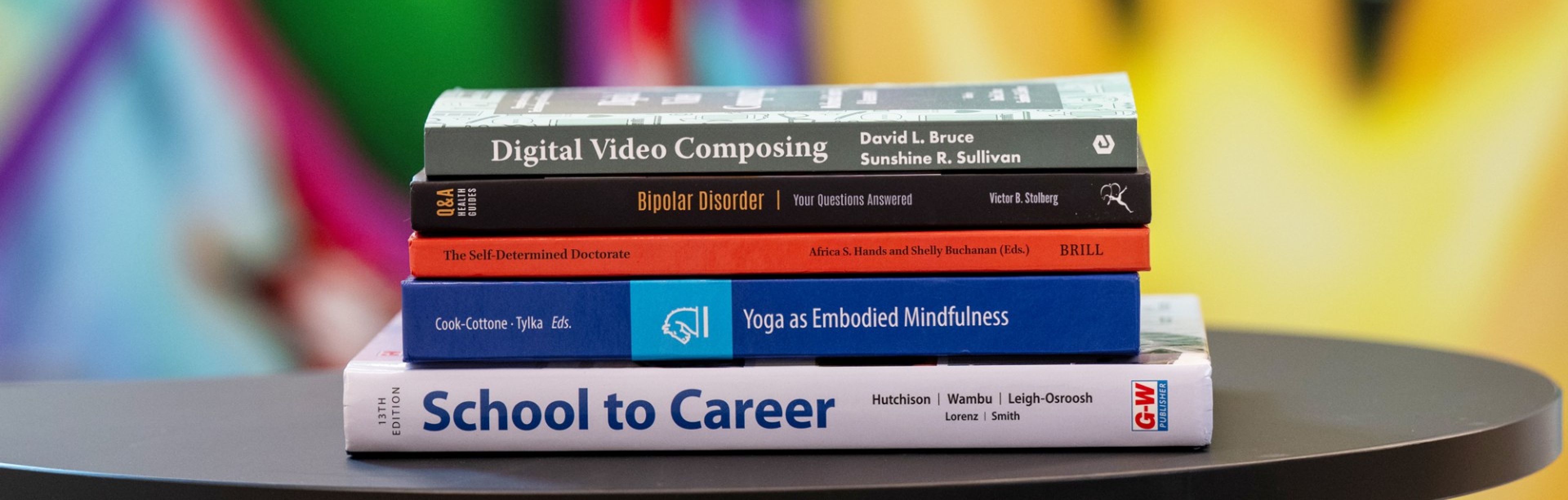 Books by GSE faculty and alumni stacked on top of one another. 
