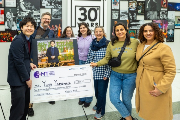 Three minute thesis check held by winning student.
