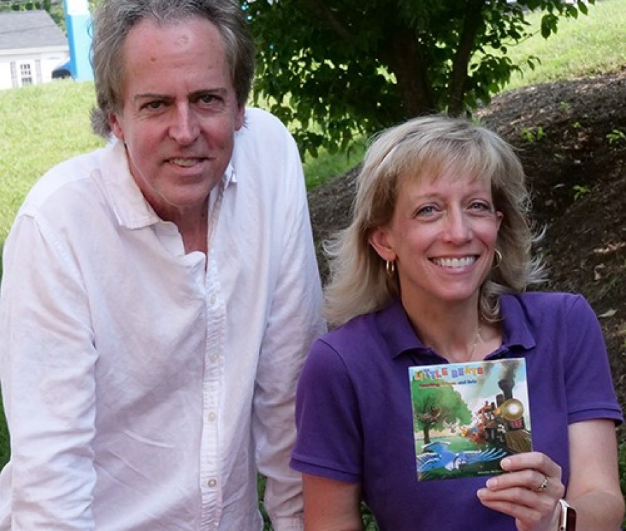 Jennifer and her husband posing for a photo with their CD cover of Little Beats.