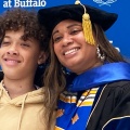 PhD graduate Dina Skeffery smiling in front of patterned background. 