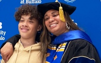 PhD graduate Dina Skeffery smiling in front of patterned background. 