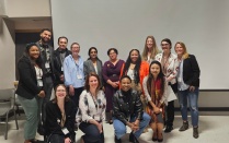 College students at symposium pose as a group. 