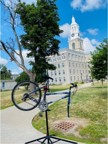 Zoom image: A partially assemble bucycle propped up in front of Hayes Hall on UB's South Campus. 