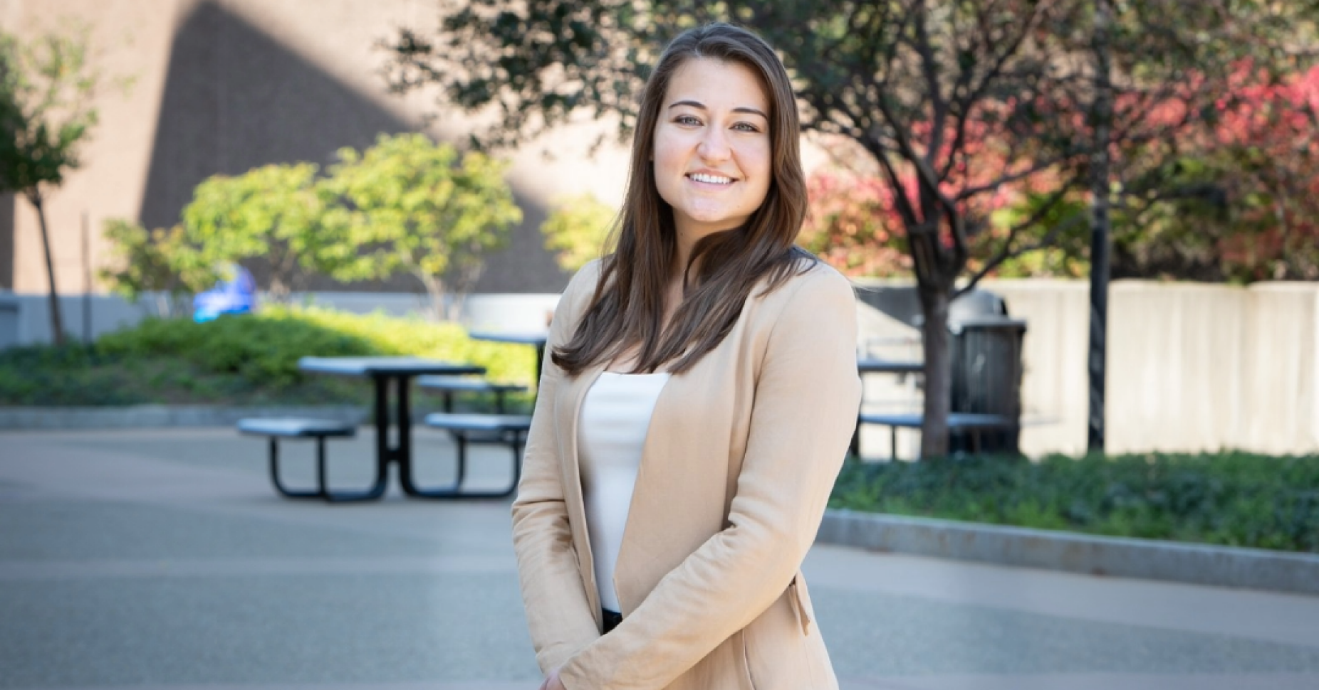 Tiffany Karalis Noel, PhD standing on walkway with picnic tables behind her. 