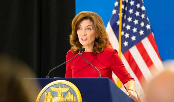 New York State Governor Kathy Hochul speaking at a podium at a press conference. 