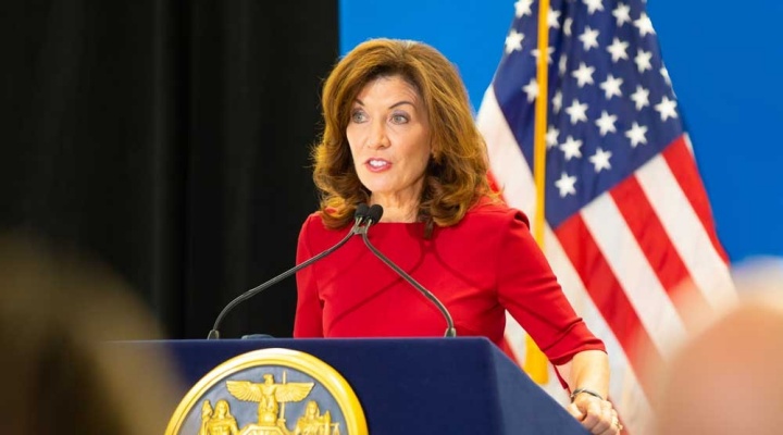 New York State Governor Kathy Hochul speaking at a podium at a press conference. 