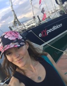 Zoom image: Alexa standing in front of eXXpedition sailboat close up