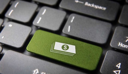 Black keyboard with green key with money symbol. 