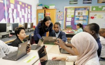 Female teacher engaging with students in the classroom. 