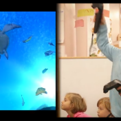 Young child wearing virtual reality goggles in our Early Childhood Research Center, with teacher, other students, TV monitor with sea turtles and fish displayed underwater. 