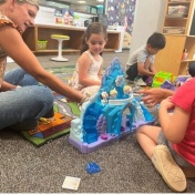 UB student playing with ECRC students in Fisher Price Play Lab. 