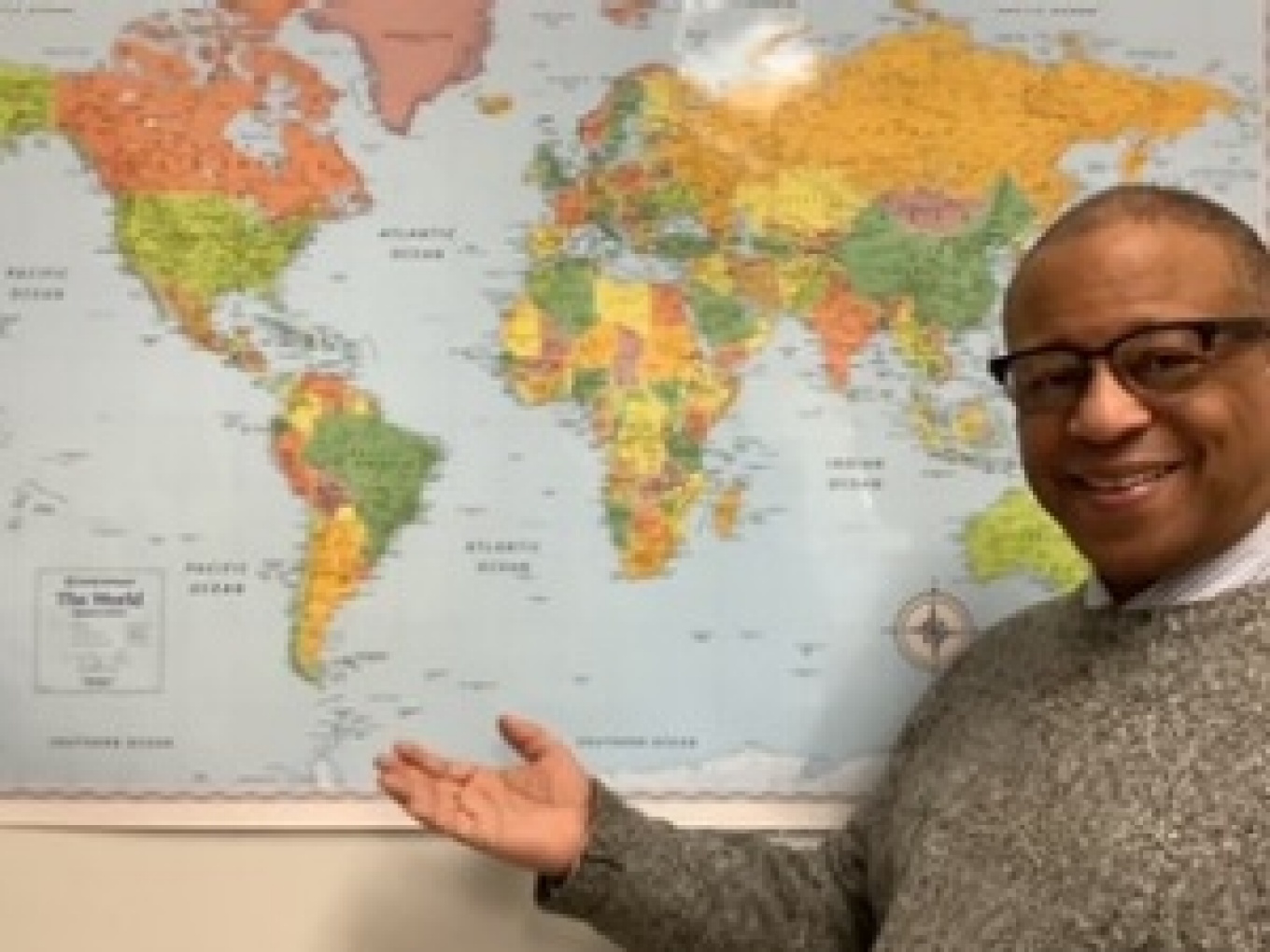 Portrait of Gary Crump in front of world map. 