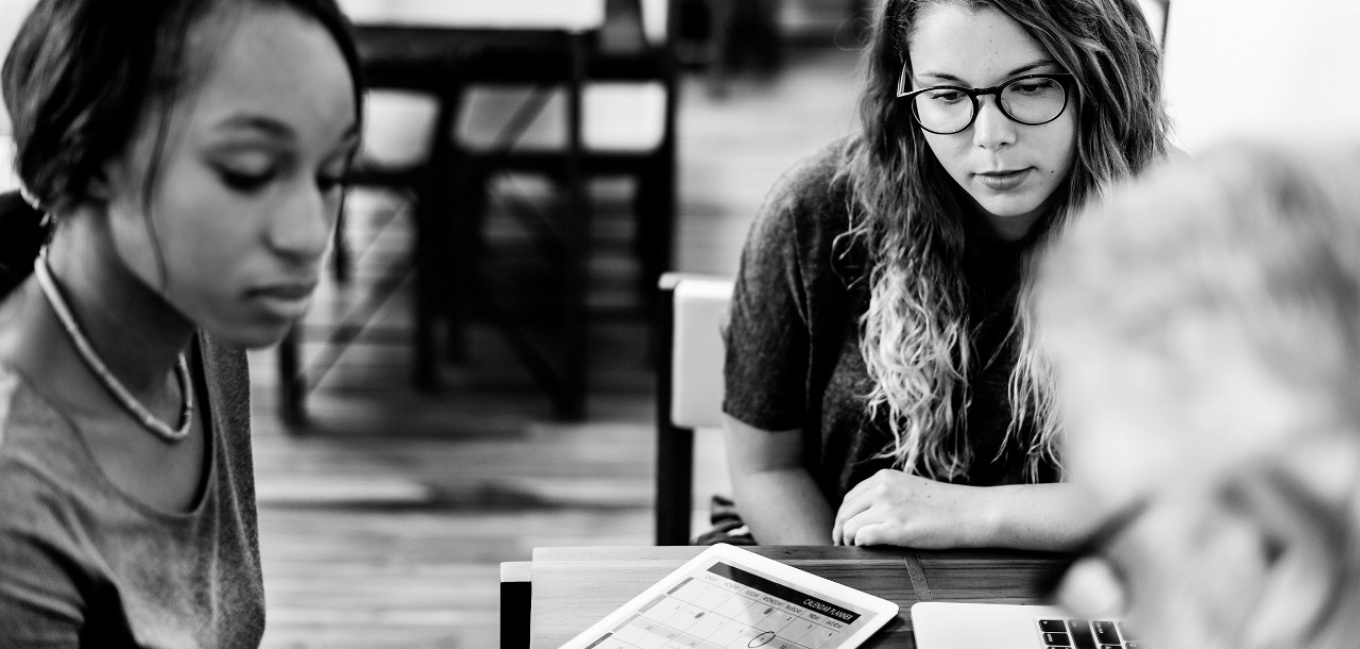 Students working with an advisor on electronic devices. 