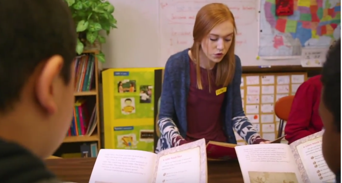 Graduate student reading to secondary school students in Buffalo Public Schools. 