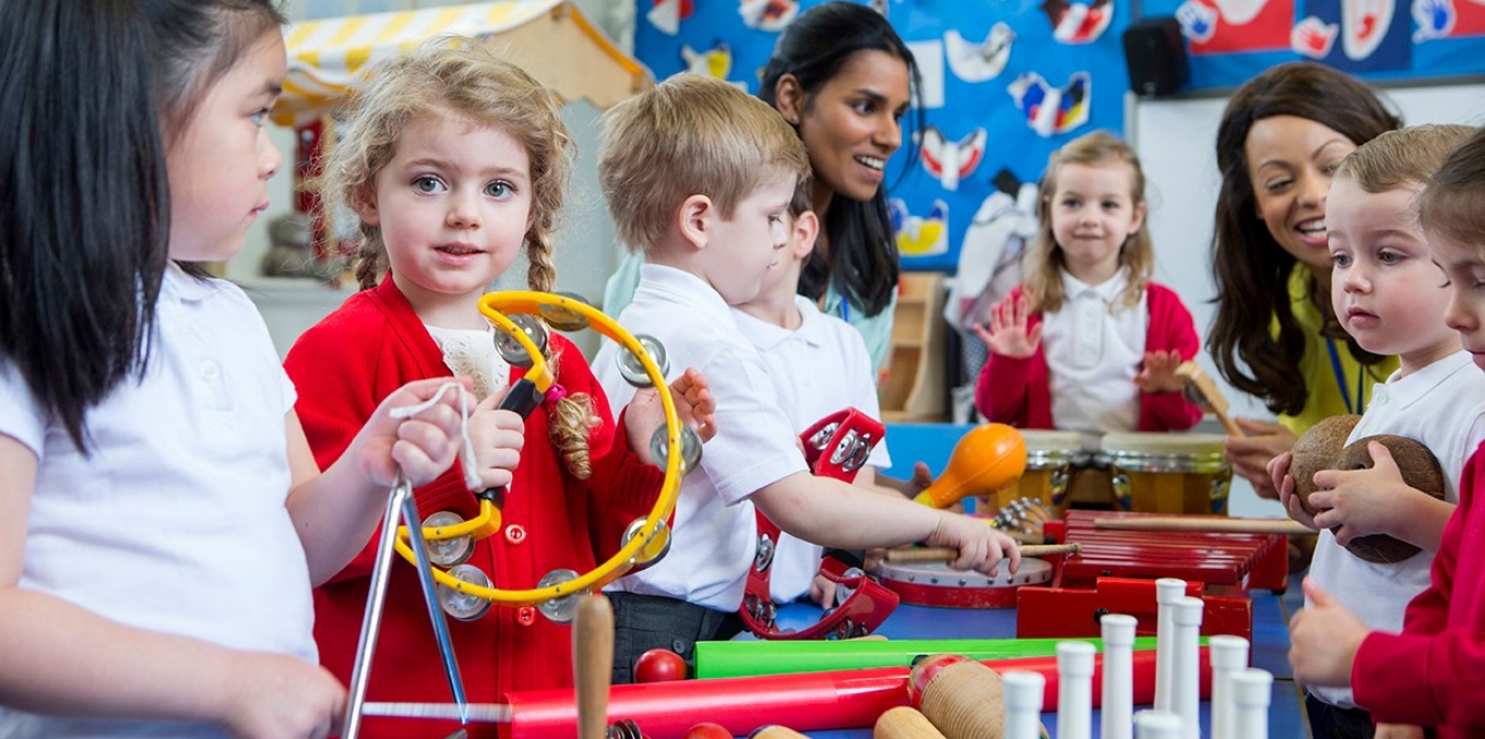 Kids playing with musical instruments in a classroom. 