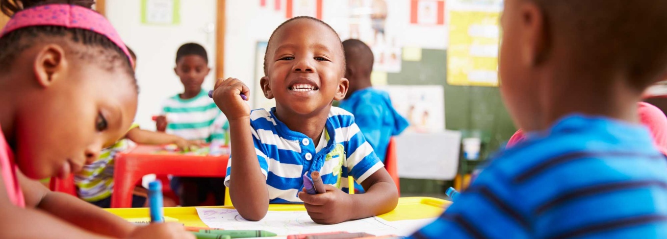 Young preschool aged child in a classroom coloring. 