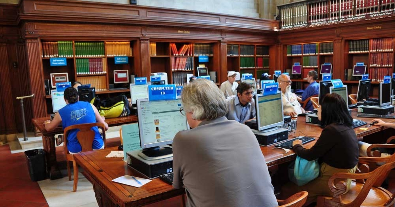 Community members working on computers in a public library. 