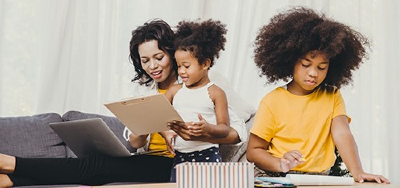 Mom working from home while also teaching two children. 