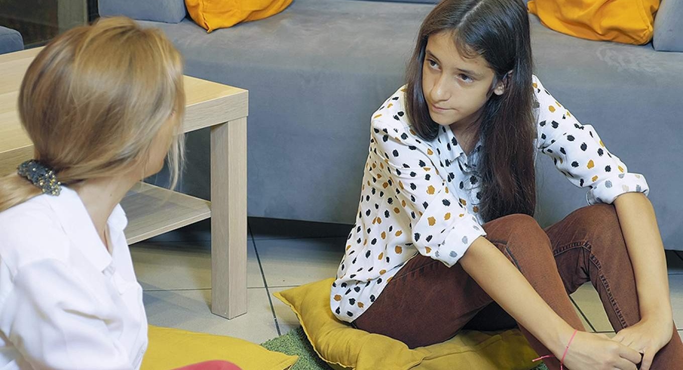Student sitting with a counselor. 