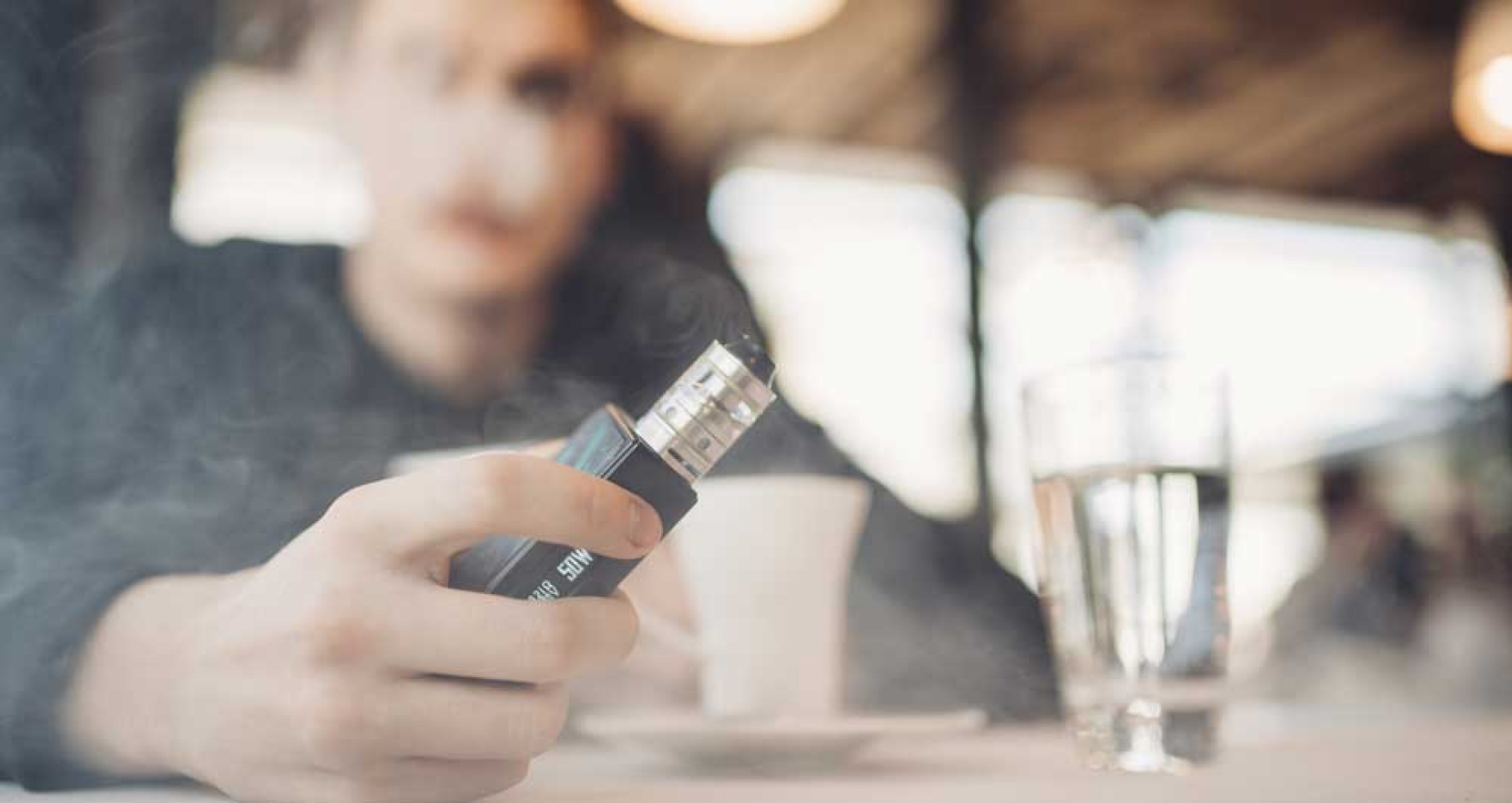 Close up of an e-cigarette in a cloud of smoke. 