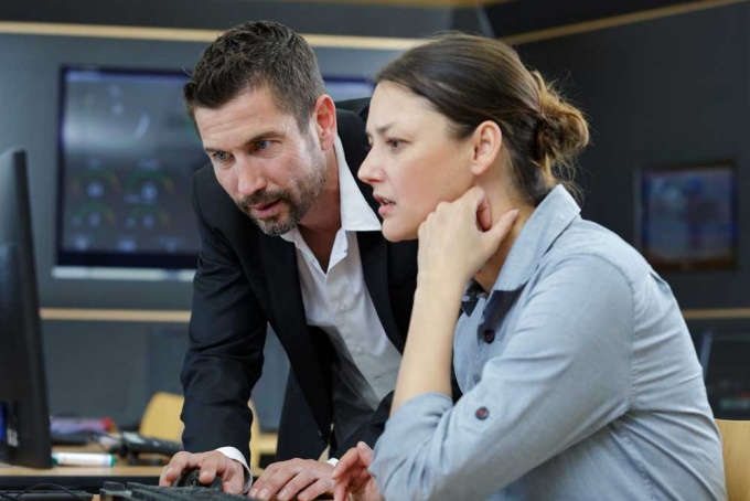 Professor working with a student at a computer screen.