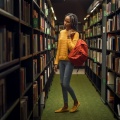 Student in book stacks in a library. 
