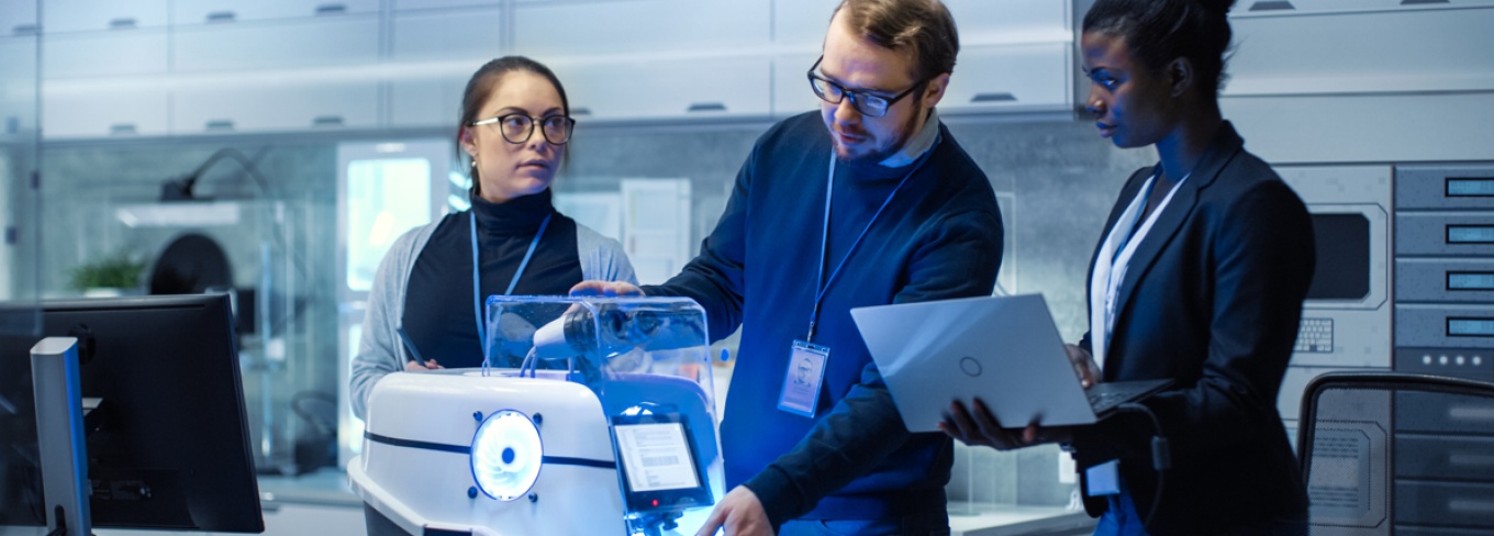 Professor working with students in a tech classroom. 
