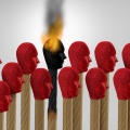 Conceptual image of matches in the shape of human heads, one lit and burning out signifying the idea of "burnout.". 