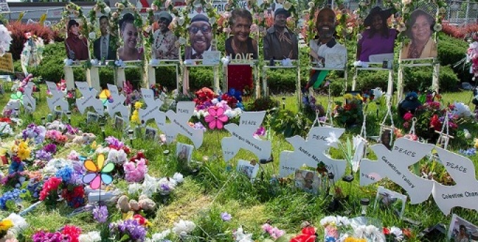 Image of flowers and peace doves set on the ground in honor of those who lost their lives at the May 14, 2023 Tops shooting in Buffalo, NY. 