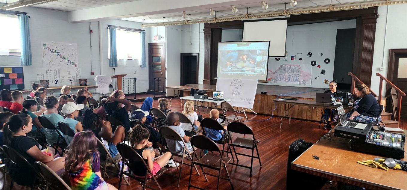 Students in auditorium in Buffalo, NY, watching presentation about the roots of rap. 