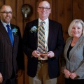 Steven Harvey, PhD ’97, (center) holds an award with UB School of Social Work Dean Keith A. Alford, PhD, and Catherine Dulmus, PhD, professor, associate dean for research and director of the Buffalo Center for Social Research in UB’s School of Social Work. 