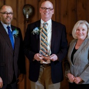 Steven Harvey, PhD ’97, (center) holds an award with UB School of Social Work Dean Keith A. Alford, PhD, and Catherine Dulmus, PhD, professor, associate dean for research and director of the Buffalo Center for Social Research in UB’s School of Social Work. 