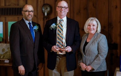 Steven Harvey, PhD ’97, (center) holds an award with UB School of Social Work Dean Keith A. Alford, PhD, and Catherine Dulmus, PhD, professor, associate dean for research and director of the Buffalo Center for Social Research in UB’s School of Social Work. 