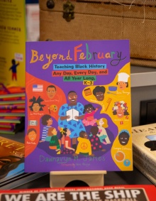 Zoom image: "Beyond February" in a stand surrounded by other Black history children's books. 
