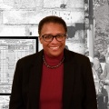 Gina Nortonsmith stands in front of a painting of Michelle Obama. 