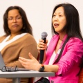 Christine Wang, PhD, speaking into a microphone during a panel session. 