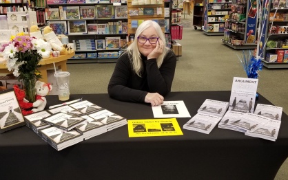 Kelly Devine, MS &rsquo;22 with her book at a signing table. 