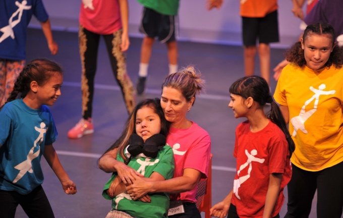 Agnes McConlogue Ferro working with a group of students. One student is in a motorized wheelchair. 