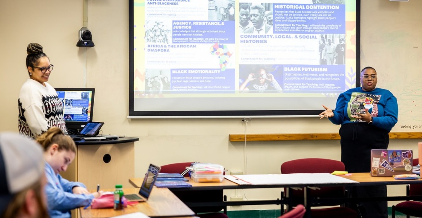 Christina King (left), clinical assistant professor of literacy education, and Dawnavyn James, graduate fellow with the Center for K-12 Black History and Racial Literacy Education, teach in Baldy Hall in January 2025. Their new class introduces early education teachers to a range of literature that can be integrated into ELA and social studies curricula. Photographer: Meredith Forrest Kulwicki. 