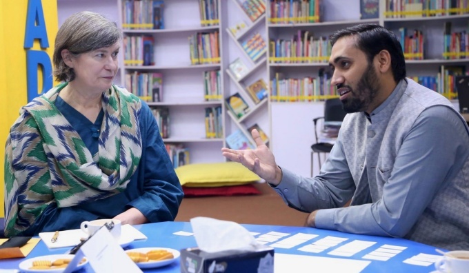 Amy VanScoy discusses the research with a librarian from Chughtai Public Library.