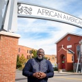 LaGarrett King standing in front of the African American Heritage Corridor. 